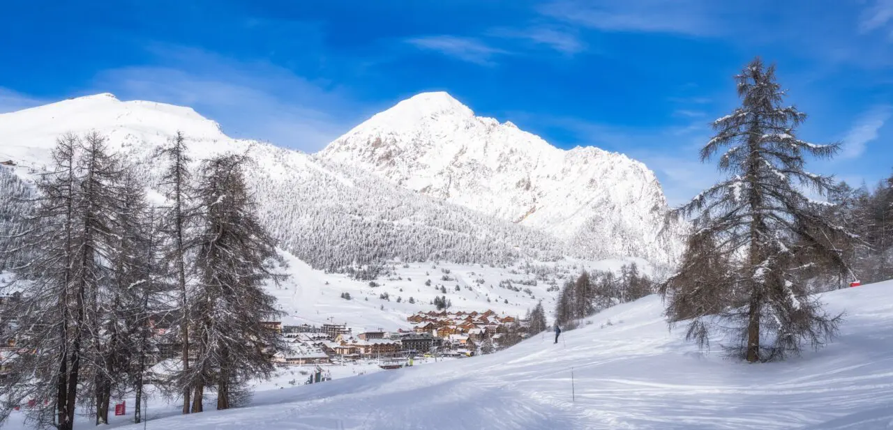 The stunning view of snowcovered mountains contrasts with the vibrant blue sky, highlighting winters beauty in a peaceful environment, ideal for exploration, Montgenèvre ski village, Alps, France
