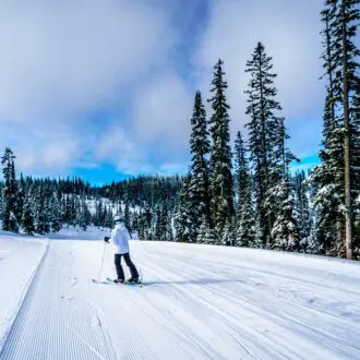 Woman Skiing in a Winter Landscape on the Ski Hills of Sun Peaks in the Shuswap Highlands of central British Columbia, Canada